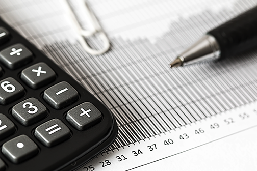 Calculator and pen sitting on top of a graph
