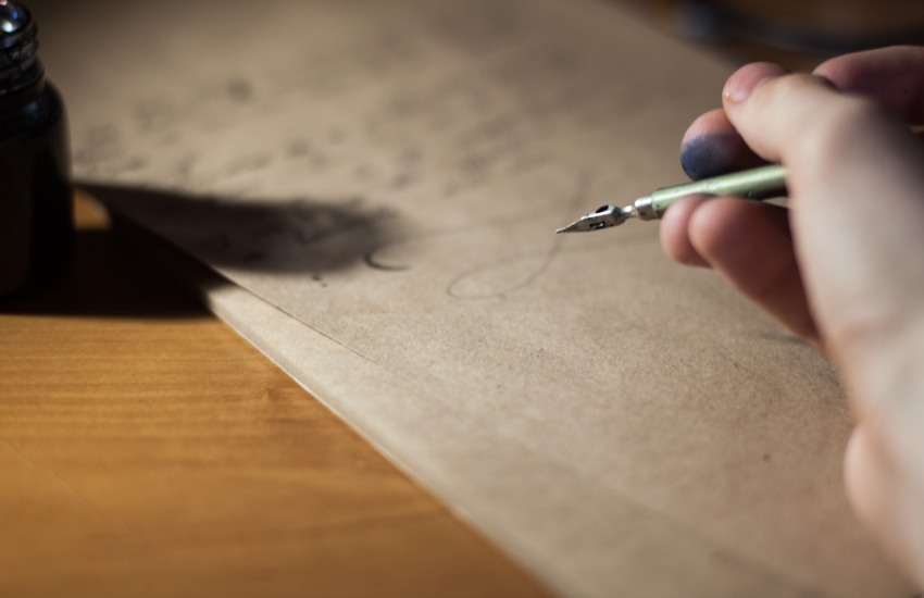 man writing with an old fashioned pen