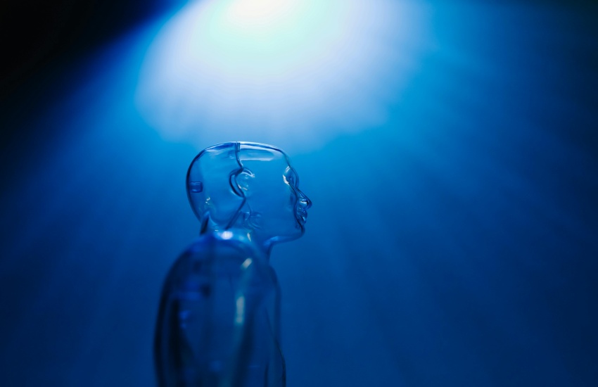 Clear mannequin on dark blue background.