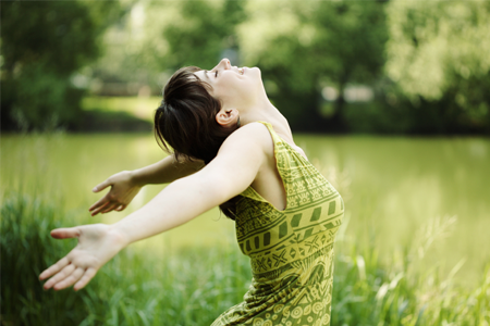 girl with arms thrown wide in a field
