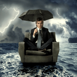man sitting in an armchair that's floating in the water, holding an umbrella, while a storm happens around him