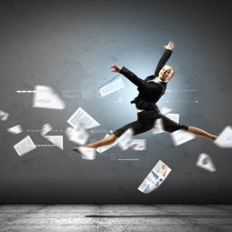 woman doing a ballet jump while papers float around her