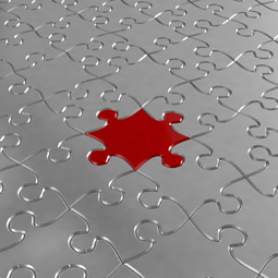 Red puzzle piece in the middle of silver puzzle pieces