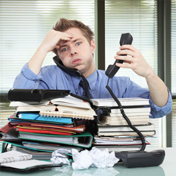 overwhelmed man with stacks of work