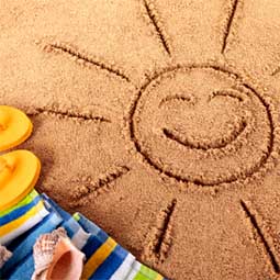 a smiling sun drawn in the sand